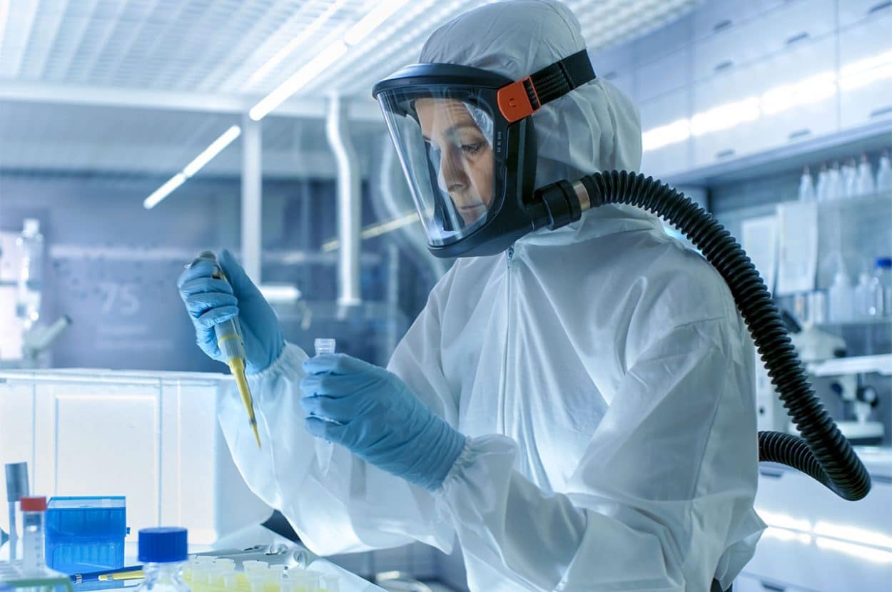 Laboratory worker, wearing a Powered Air-Purifying Respirator (PAPR). (Credit: FAULHABER)