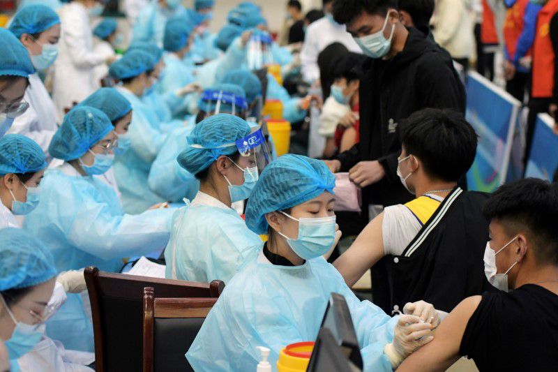 Medical workers inoculate students with the vaccine against the Covid-19 at a university in Qingdao, Shandong province, China. March 30, 2021. (Credit: China Daily via Reuters)